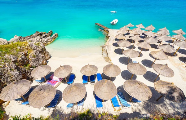 Parasoller och solstolar på stranden — Stockfoto