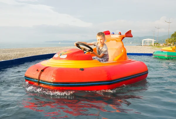 Happy kid driving toy water boat. — Stock Photo, Image