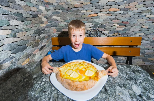 Boy eating hachapuri — Stock Photo, Image