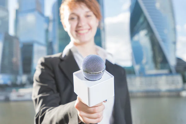 Donna in abito da lavoro con un microfono in mano — Foto Stock