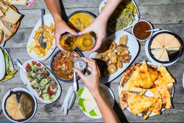 İnsanlar yemek yiyip kadeh tokuşturuyor.