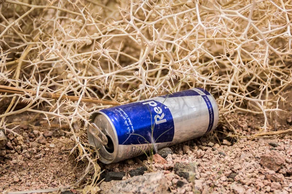 Empty cans of Red Bull in the dry desert — Stock Photo, Image