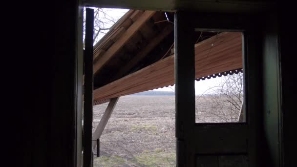 Une maison abandonnée solitaire se trouve au milieu d'un champ de blé lors d'une journée gris blustery — Video