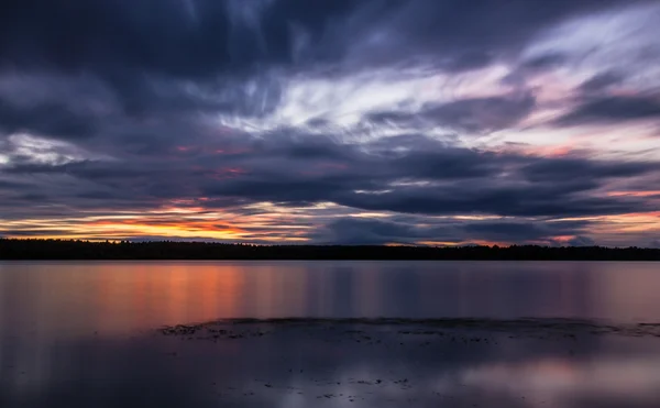 Sonnenuntergang über dem Fluss mit dramatischen Wolken — Stockfoto