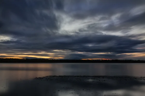 Закат над рекой с красивыми облаками — стоковое фото