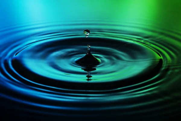 Kapka vody na modré zelené pozadí — Stock fotografie
