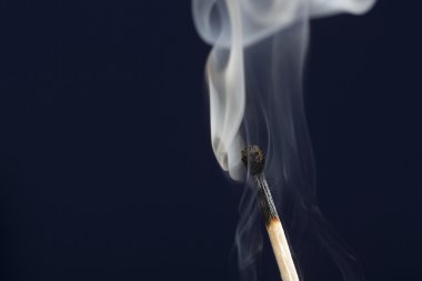 Koyu mavi zemin üzerine duman ile maç sönmüş
