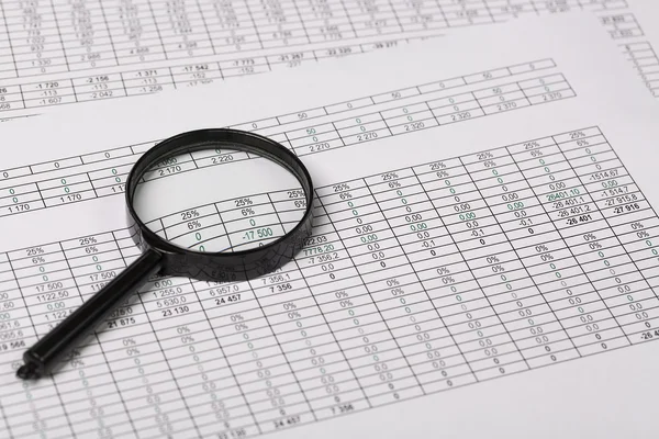 Conceptual Magnifying Glass on Reports with figures — Stock Photo, Image