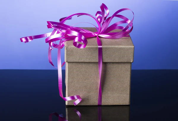 Caja de regalo con bonita cinta rosa y reflejo en azul — Foto de Stock