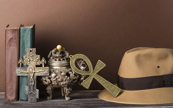 Archäologisches und abenteuerliches Konzept für verlorene Artefakte mit Hut, Vintage-Büchern, eiserner Vase, Lebensschlüssel, Vintage-Kreuz — Stockfoto