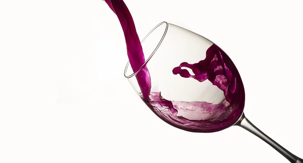 Vinho tinto derramando em um copo de vinho — Fotografia de Stock