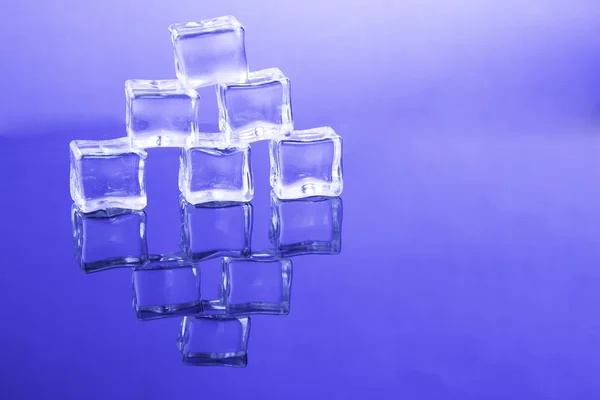 Кубики льда положить друг на друга на синем фоне — стоковое фото