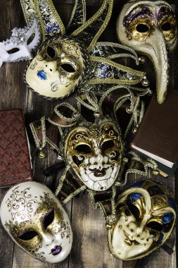 Venedik Hatıra maskeleri ile ahşap yüzey üzerinde kitaplar vintage