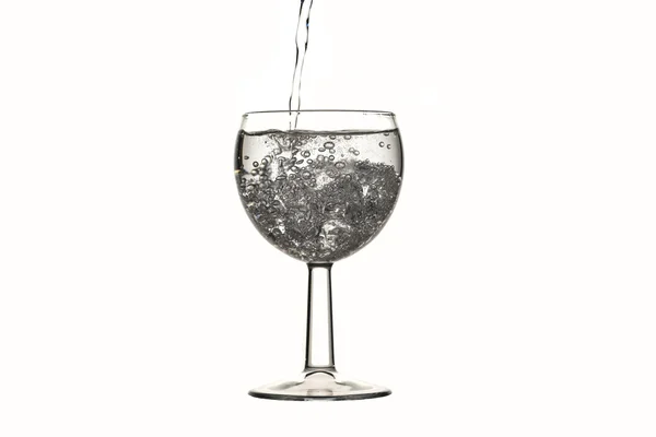 Mineral vatten hälla ett glas med is och bubblor på vit — Stockfoto