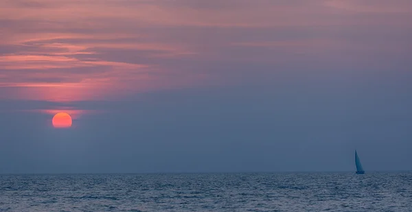 Landschaft von Meer Sonnenuntergang mit roter Sonne und Segelboot — Stockfoto