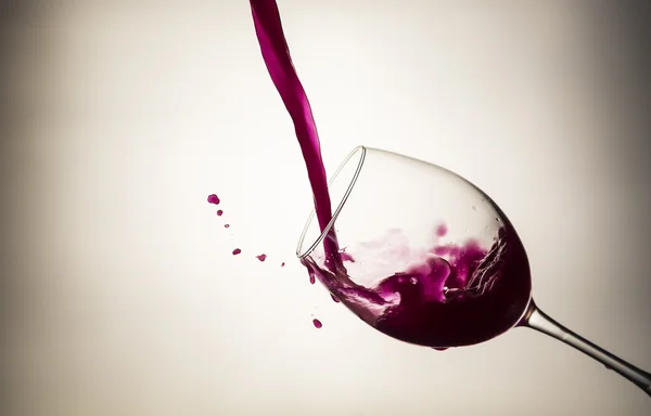 Vinho tinto derramando em uma adega com gotas de vinho — Fotografia de Stock