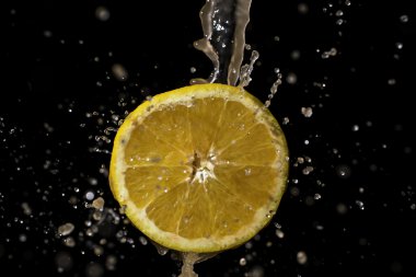 Siyah bir zemin üzerine portakal ve su sıçrama