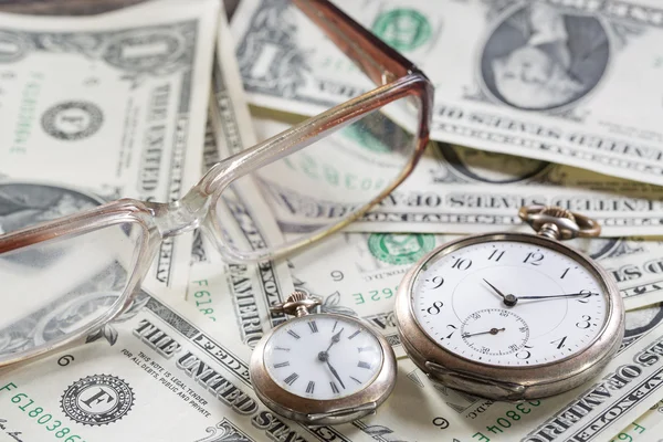 El tiempo es el concepto de finanzas de dinero con viejos relojes vintage, billetes de dólar, gafas —  Fotos de Stock