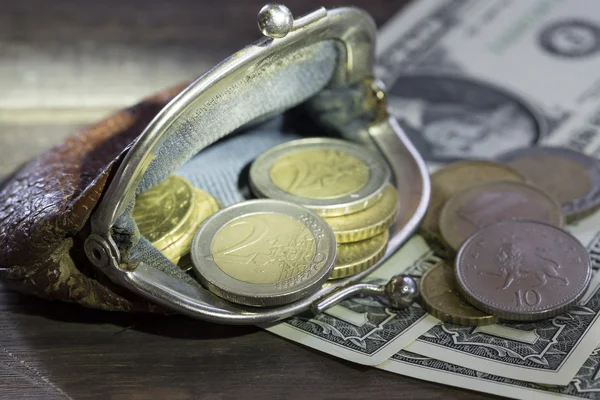 Finanzierungskonzept. Brieftasche mit Euromünzen und Dollarscheinen auf Holzgrund Stockbild