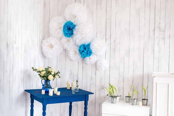 Interior design, white flowers, roses in a blue vase on a blue table with a white wooden background. — Stock Photo, Image