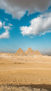 Giza Mısırın muhteşem piramidi, güneşli bir günde panoramik bir manzara ve mavi gökyüzü.