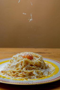 Peynir rendelenir ve makarna tabağına düşer.