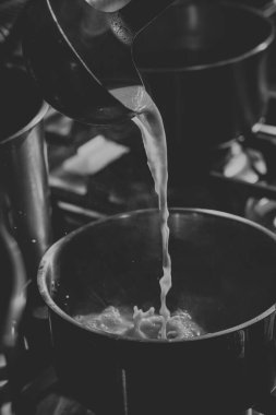 Şef ramen pişirmek için bir tabağa çorba dolduruyor.