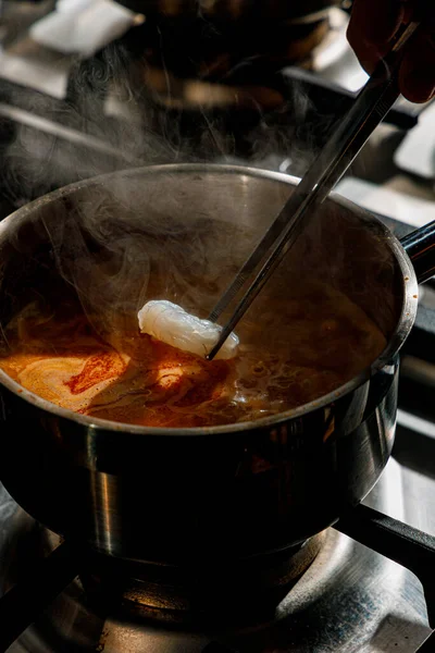 Profesyonel bir mutfakta erişteye karides ekliyorum.