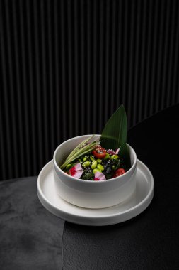 Menü için ayrılmış beyaz bir tabakta Asya soslu salatalık ve fasulye salatası.