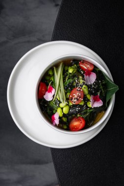 Menü için ayrılmış beyaz bir tabakta Asya soslu salatalık ve fasulye salatası.