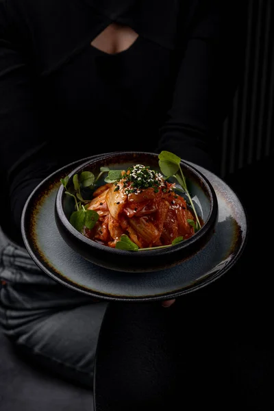 Lokantada tabakta lahana turşusu, karanlık bir arka plan.