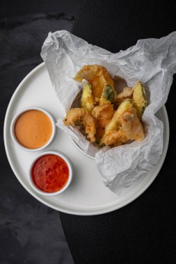 Menü için beyaz bir tabakta soslu tempura içinde karidesler.