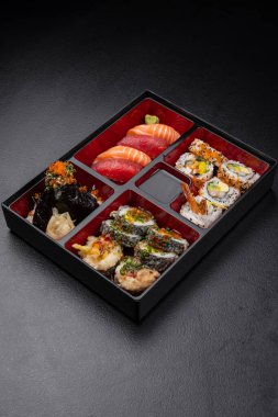 Japon stili bento kutusu. Nigiri ve suşi koyu arka planda.