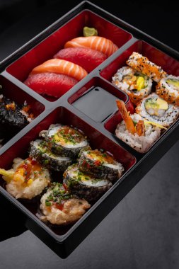 Japon stili bento kutusu. Nigiri ve suşi koyu arka planda.