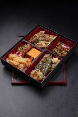 Gyoza, sushi, somon ve tempura içeren Bento kutusu menü için izole edilmiş.