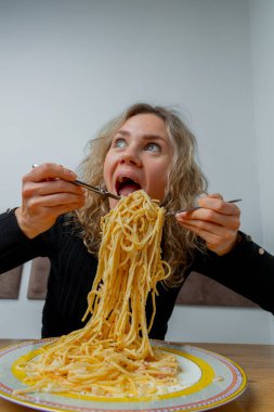 Kafede makarna yiyen karizmatik bir kız. Yüzünde sanatsal bir ifade var..
