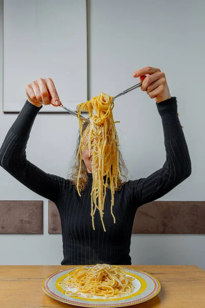 Kafede makarna yiyen karizmatik bir kız. Yüzünde sanatsal bir ifade var..