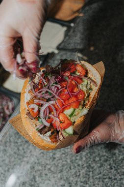 Çörekte kebap pişirme süreci. Şefin elleri. Soslar, sebzeler, et