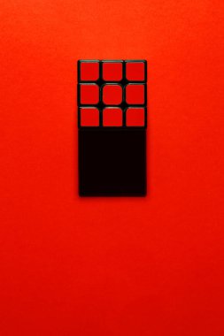 Kırmızı arkaplandaki Rubik küpü gölge sanatı yaratıyor