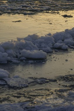 Güneş kışın donmuş bir nehrin üzerinde batar. Buz parçacıkları
