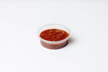 Menü için izole edilmiş beyaz arkaplandaki bir kabın içindeki acı kırmızı sos