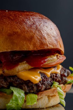 Burger, menü için izole edilmiş makroyu kapat. Peynir, pirzola, sebze ve sos.