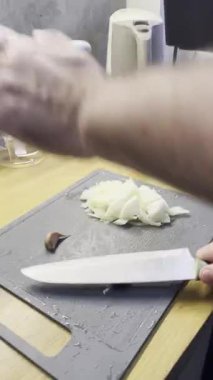 Chopping onions and garlic. Chopping onions and crushing garlic before frying on a gray board