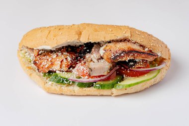 Kebab in a bun with meat and vegetables on a white background isolated