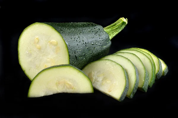 Abobrinha vegetal fresca em um fundo preto — Fotografia de Stock