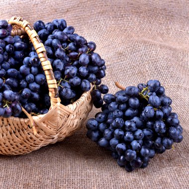 Yakın çekim bir hasır sepet içinde siyah üzüm.