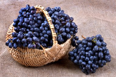 Yakın çekim bir hasır sepet içinde siyah üzüm.