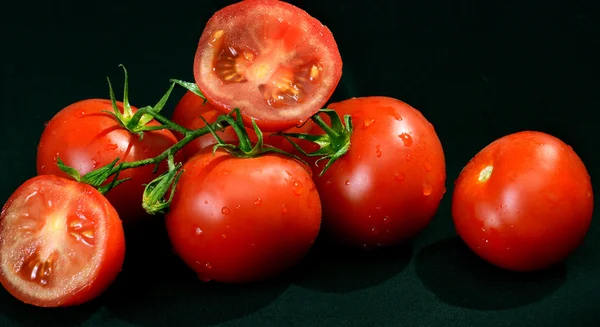 Frische rote Tomaten auf schwarzem Hintergrund — Stockfoto