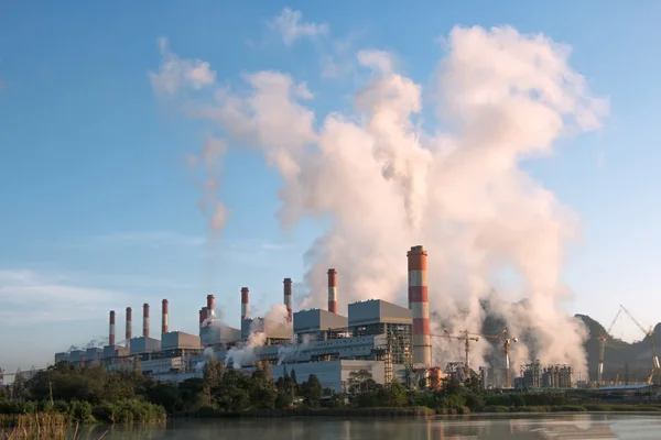Coal-Fired santral üzerinden mavi gökyüzü ile sabah gün içinde duman.