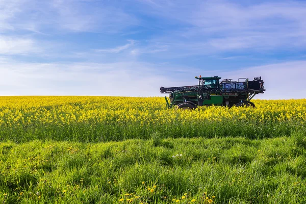 Landwirtschaftliches Fahrzeug auf Rapsfeld — Stockfoto